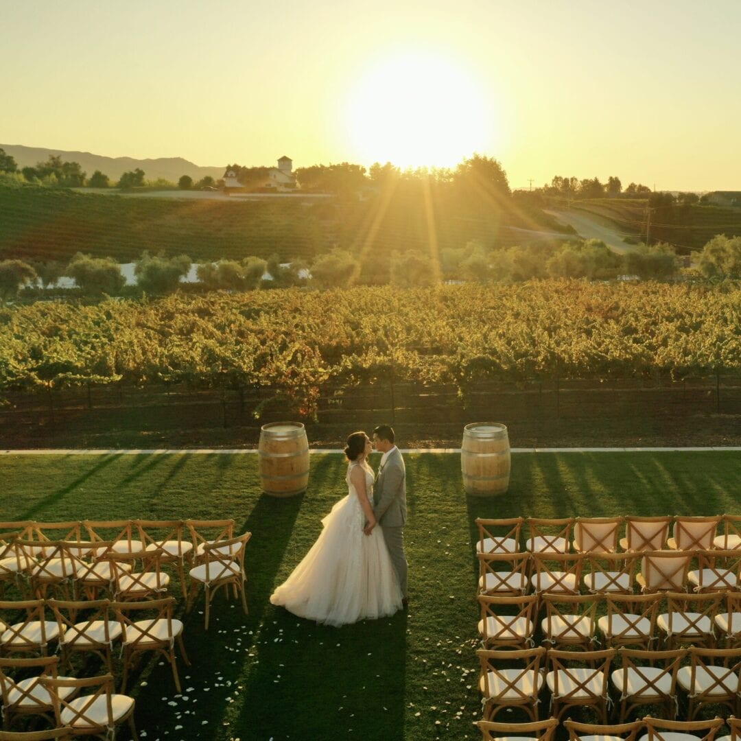 A couple is standing in front of an empty field.